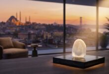 Eine einzelne, perfekte Zahnverblendschale aus Keramik im scharfen Fokus, im Hintergrund eine unscharfe, goldene Ansicht der Istanbuler Skyline bei Sonnenuntergang, die Medizintourismus darstellt.