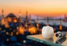 Ein makelloses Zahnimplantat und eine Zirkonkrone in Nahaufnahme auf einer glänzenden Oberfläche, mit einem unscharfen, malerischen Blick auf die Skyline von Istanbul im Hintergrund bei Sonnenuntergang, was den Zahntourismus in der Türkei darstellt.