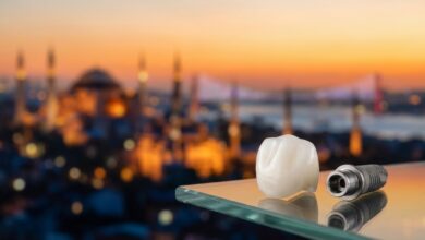 Ein makelloses Zahnimplantat und eine Zirkonkrone in Nahaufnahme auf einer glänzenden Oberfläche, mit einem unscharfen, malerischen Blick auf die Skyline von Istanbul im Hintergrund bei Sonnenuntergang, was den Zahntourismus in der Türkei darstellt.