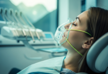 Nahaufnahme eines Patienten in einem modernen Zahnarztstuhl, der tief entspannt und ruhig wirkt. Eine subtile Andeutung einer Sedierungsmethode (z.B. Nasenmaske oder IV-Zugang) ist erkennbar. Der Hintergrund zeigt eine saubere, moderne Zahnklinik mit einem verschwommenen Ausblick auf eine Schweizer Landschaft. Sanfte, kühle Beleuchtung. Keine Schrift.