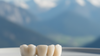 A close-up, photorealistic image of a sparkling white ceramic dental bridge resting on a sterile surface. The background is a highly blurred, out-of-focus view of the majestic Swiss Alps under a bright, clear sky. The focus is sharp on the dental bridge, highlighting its intricate detail and quality.
