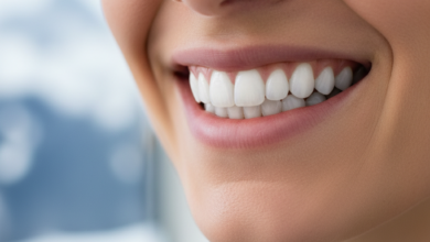 Close-up of a person's face showing a wide, confident smile with bright, perfectly aligned white teeth. The background is out of focus, suggesting a clean, serene environment with subtle hints of mountain scenery.