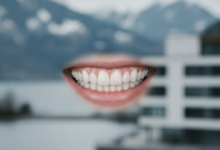 Close-up of a bright, healthy, and perfectly restored natural smile with impeccably aligned teeth, against a very softly blurred background hinting at a pristine Swiss Alpine landscape and modern architectural elements.