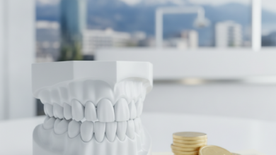 A close-up, conceptual image showing a clean dental model, a stack of golden coins, and blurred abstract insurance documents, set against a softly blurred Swiss mountain backdrop, symbolizing dental care costs and insurance in Switzerland.