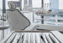 A close-up of sterile, gleaming dental instruments on a tray in a modern clinic, with a blurred background hinting at the city of Basel, Switzerland.